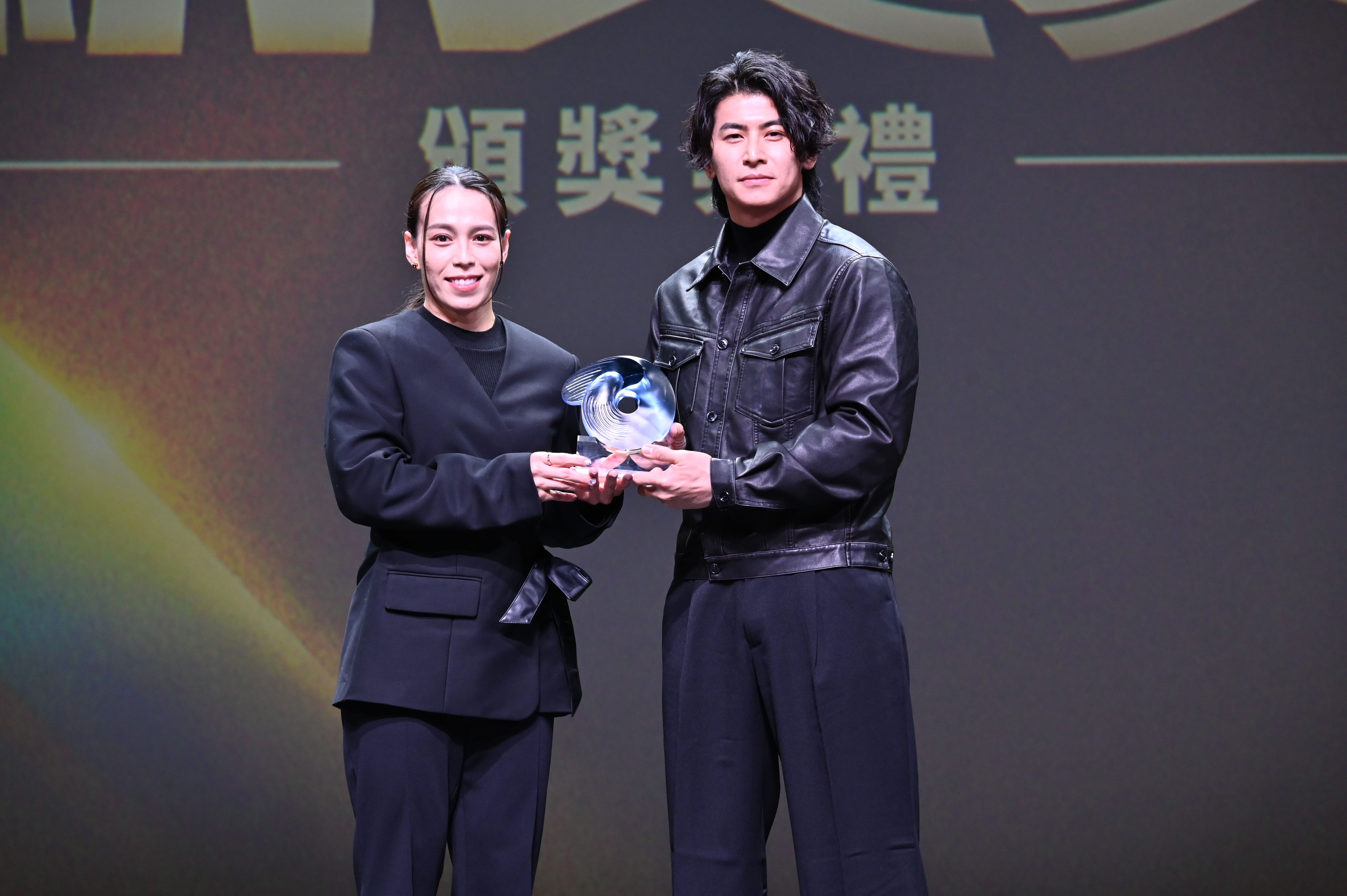 陳傑憲（圖右）從四度最佳女運動員獎得主郭婞淳手中接過最佳男運動員獎座。圖片來源：運動部提供